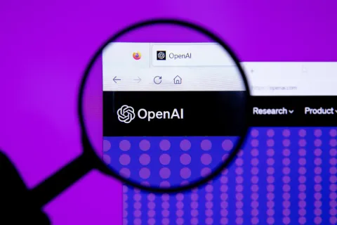 放大鏡下的 OpenAI 網站標誌與瀏覽器分頁，紫色背景